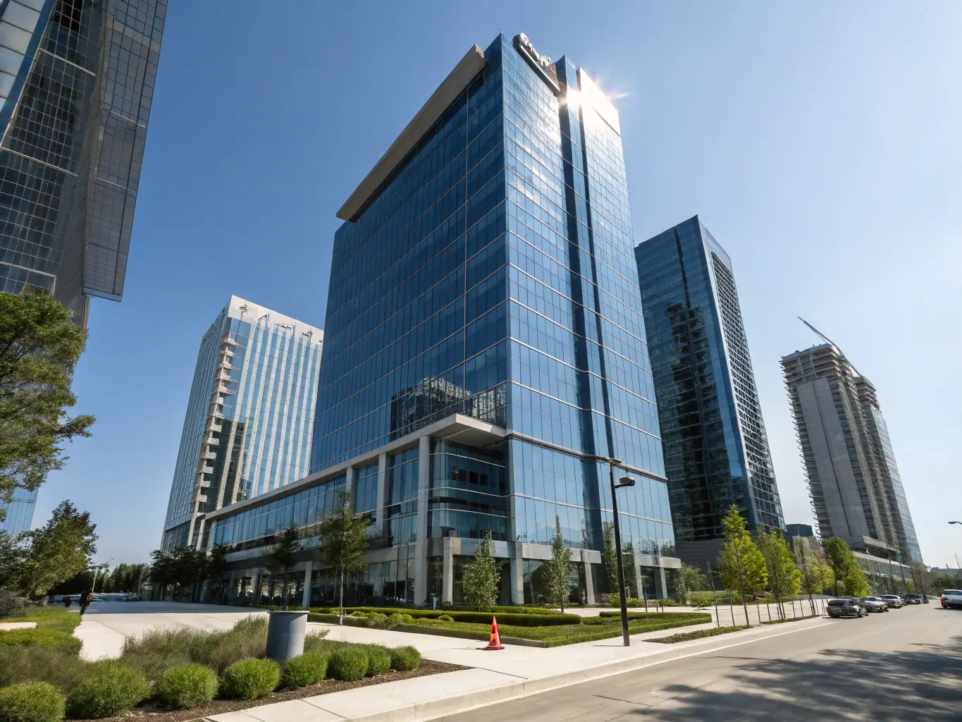 A modern office building facade at sunset, showcasing its energy-efficient windows and smart lighting system, symbolizing reduced energy consumption.